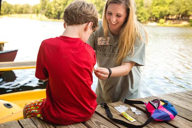 A camp nurse helping child